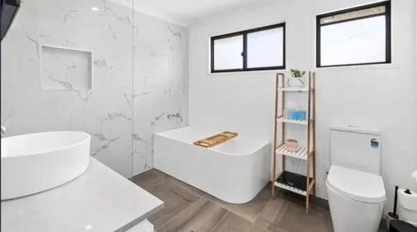 Completed bathroom renovation in Alexandra Hills with a freestanding bath and marble-look wall tiling