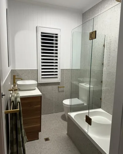 Completed bathroom renovation in Camp Hill with a shower over bath and brass tapware
