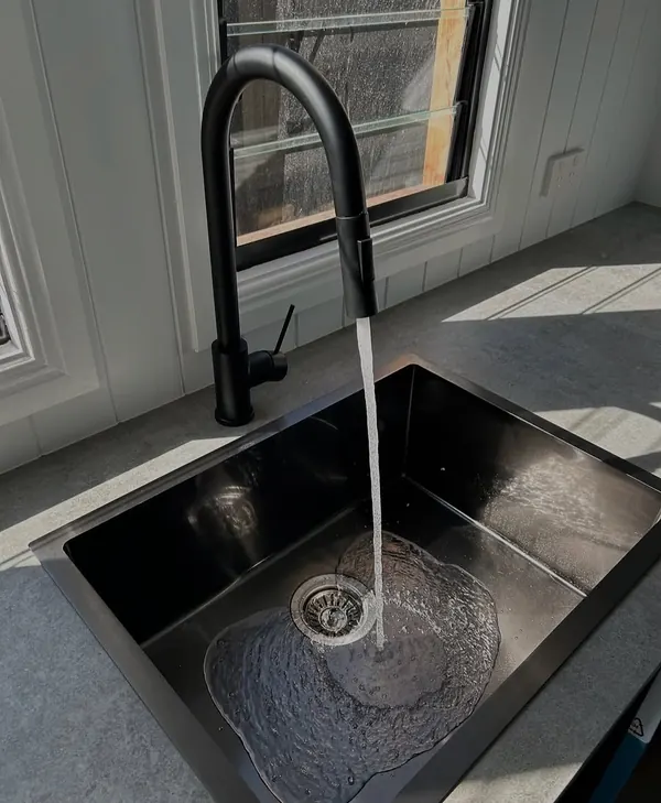 Black granite sink and matching mixer tap installed in a kitchen