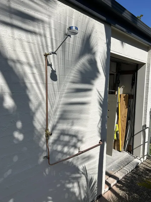 Downpipe run and brackets fixed to a rendered wall