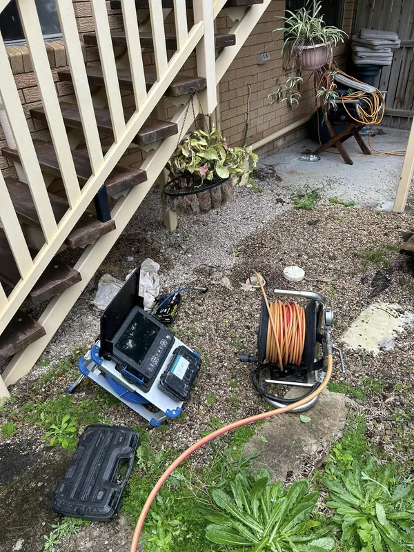 Drain camera and hose reel set up beside a house for a blocked drain
