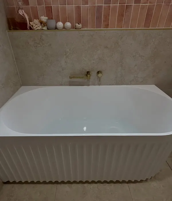 Freestanding bath with brass floor-mounted tapware