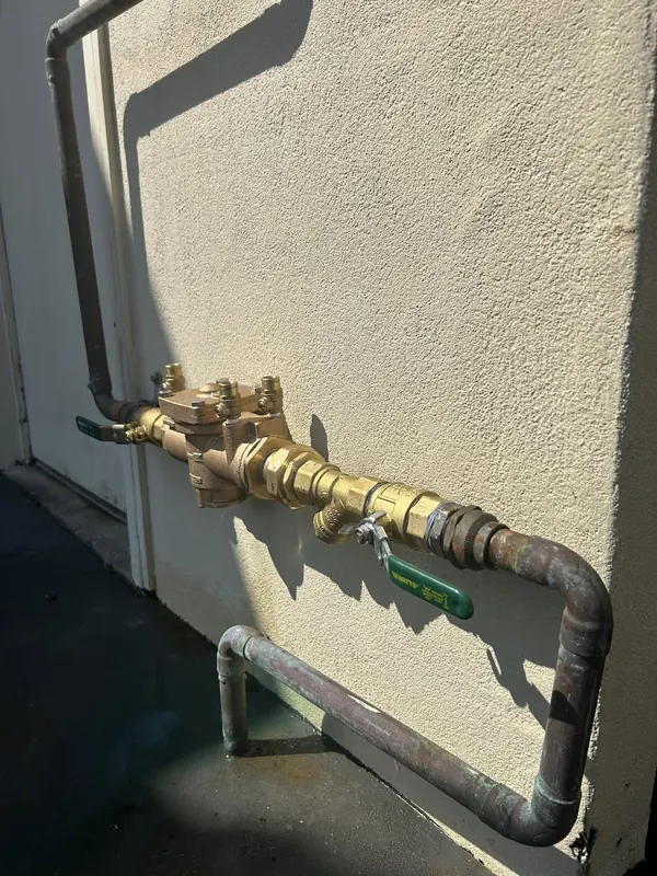New brass garden tap and dual check valve on an external wall