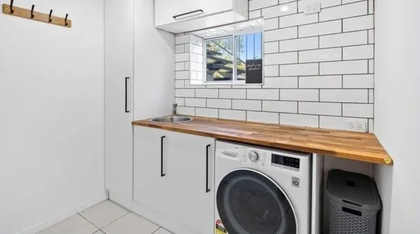 Completed laundry renovation in Rochedale with subway tiling and a timber benchtop