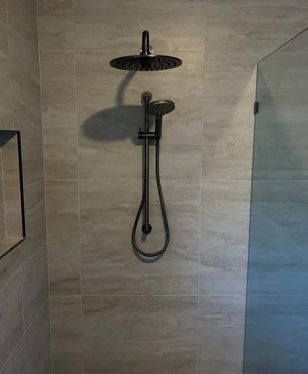Rain shower head and rail installed in a tiled shower