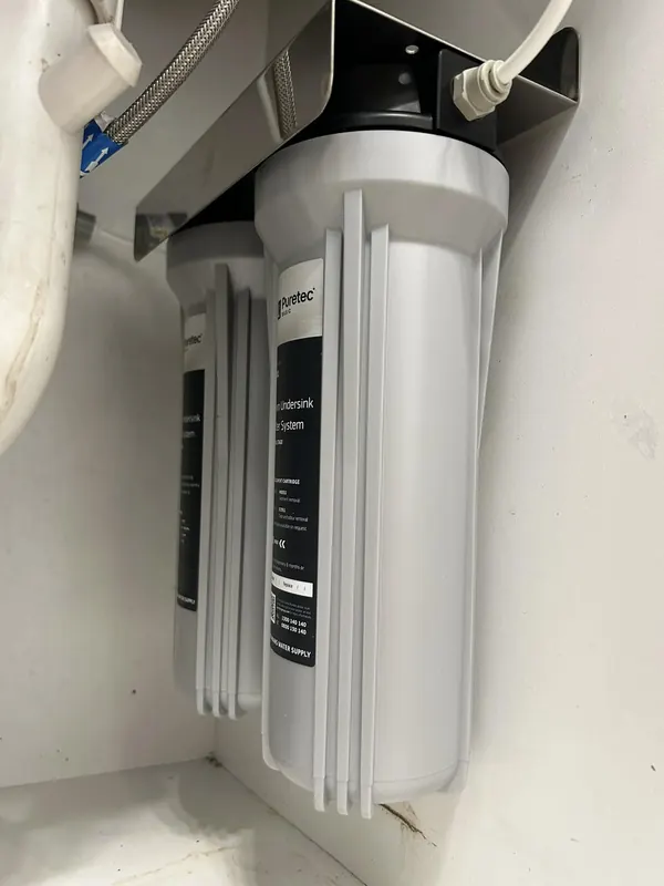Under-sink water filter system installed in a kitchen cabinet